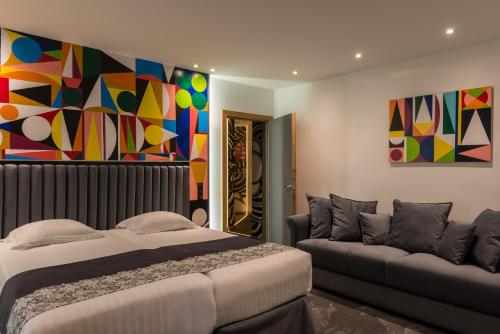 a bedroom with a bed and a couch at Hotel Aida Opera in Paris