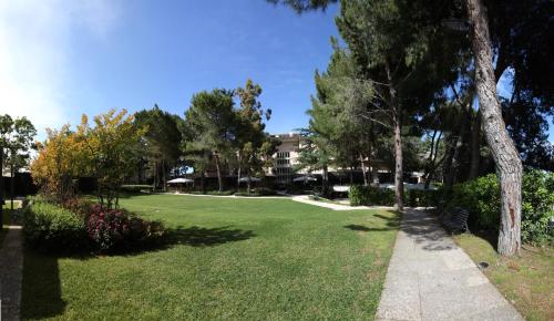 a park with green grass and trees and a building at Villa Maria Hotel & SPA in Francavilla al Mare
