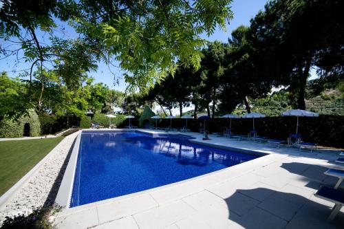 a swimming pool with chairs and umbrellas in a yard at Villa Maria Hotel & SPA in Francavilla al Mare