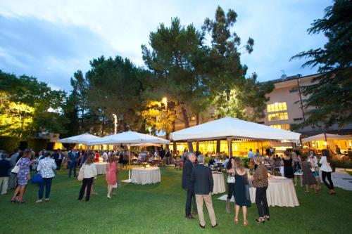 a group of people standing around tables in a park at Villa Maria Hotel & SPA in Francavilla al Mare