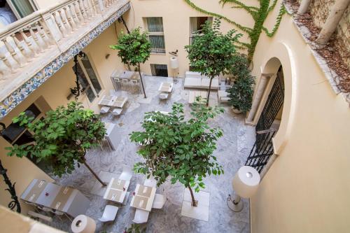 una vista aérea de un patio con mesas y árboles en Petit Palace Santa Cruz, en Sevilla