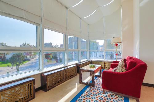 a living room with windows and red chairs and a table at KADORR Hotel Resort & Spa in Odesa