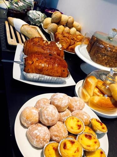 a table topped with plates of food and pastries at Alpha Hotel and Aparthotel in Tienen