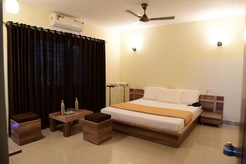 a bedroom with a bed and a black curtain at Shesha KUTEERA in Subrahmanya