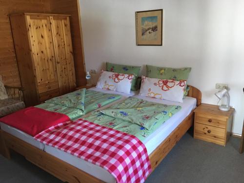 a bedroom with a bed with a checkered blanket at Zum Bergbauer in Mittenwald