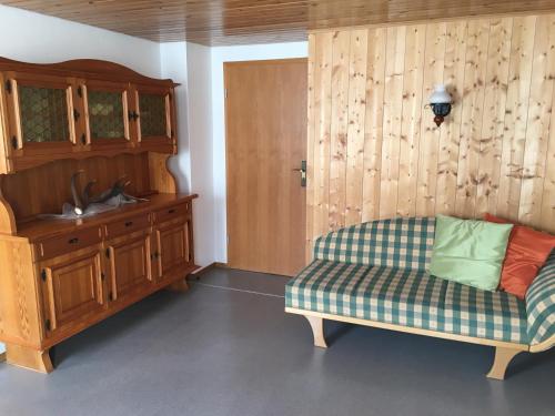 a living room with a couch and a wooden cabinet at Zum Bergbauer in Mittenwald