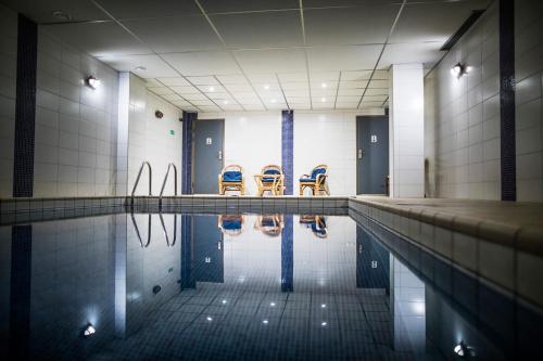 - une piscine avec des chaises dans l'eau dans l'établissement First Hotel Royal, à Säffle