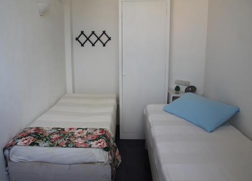 トロペアにあるMini Appartamento Tropea centro "Triangolo al Tondo" vista mareのベッド2台と青い枕が備わる客室です。