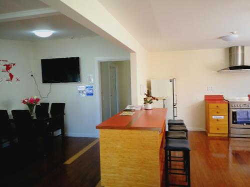 a living room with a kitchen with a counter and chairs at Oxford Queenette Backpackers in Oxford