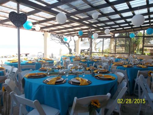 a banquet hall with blue tables and white chairs at Neptunes Cove in Kei-mouth Village