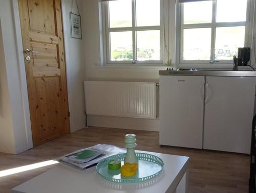 a kitchen with a bottle on a plate on a table at Kristjanshavn in Miðvágur