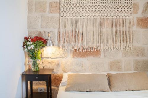 a bedroom with a bed and a table with a vase of flowers at Elena's House 6 in Polignano a Mare