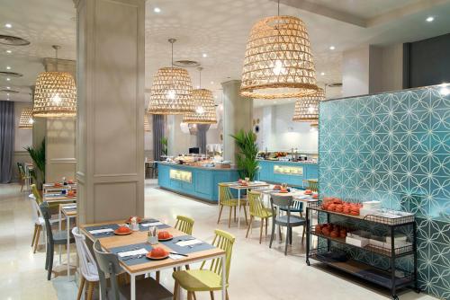 a restaurant with tables and chairs and chandeliers at Vincci Lys in Valencia