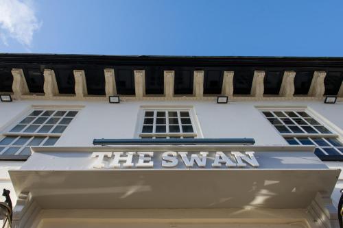 a sign for the swan on the front of a building at The Swan by Innkeeper's Collection in Coleshill