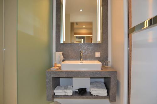 a bathroom with a sink and a mirror at Hotel Hecher in Wolfsberg