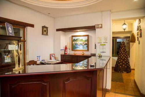 a lobby with a counter and a christmas tree at Casa Kirvá Hotel in Cobán