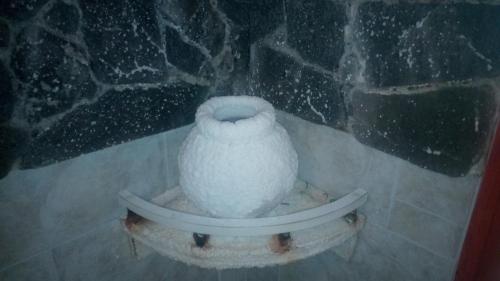 a white vase sitting on top of a stone wall at Vencsellői Wellness Vendégház in Gávavencsellő