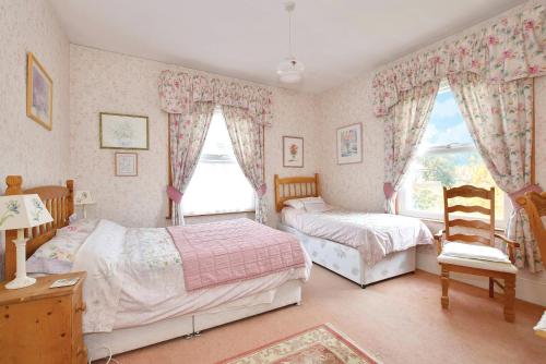 een slaapkamer met 2 bedden en een raam bij Sunny Bank Guest House in Hythe