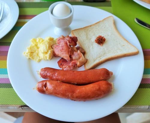 a plate of breakfast food with eggs sausage and toast at Amazing Villa in Matara