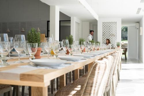 a long table with white plates and wine glasses at Octant Vila Monte in Moncarapacho