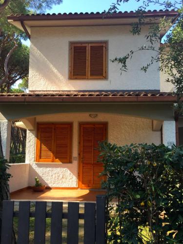 a house with orange doors and a fence in front of it at Girino II in Principina a Mare