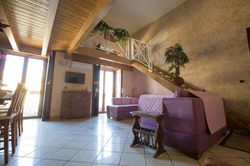 a living room with purple couches and a staircase at Suite Orchidea by Dimorra in Naples
