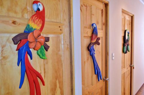 a colorful parrot on the wall next to a door at Guesthouse Casa Lapa in Alajuela City