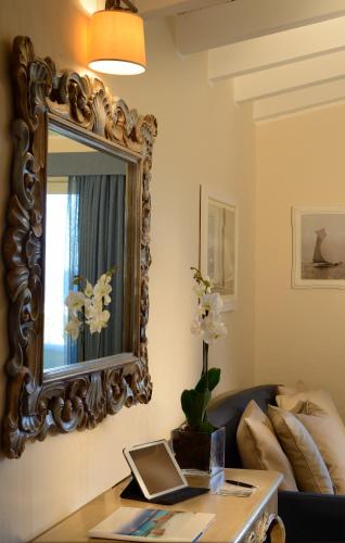 a living room with a mirror and a table at CPH | Pevero Hotel in Porto Cervo