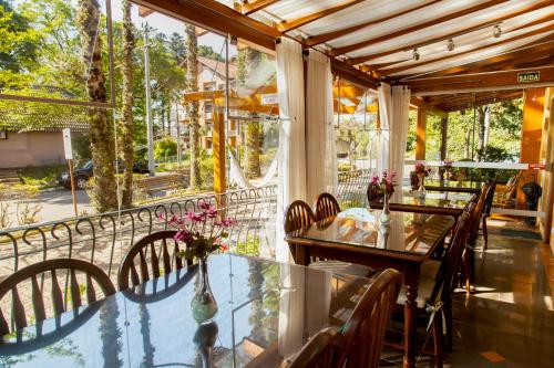 Un comedor con una mesa de cristal y sillas. en Pousada Águia Branca, en Gramado