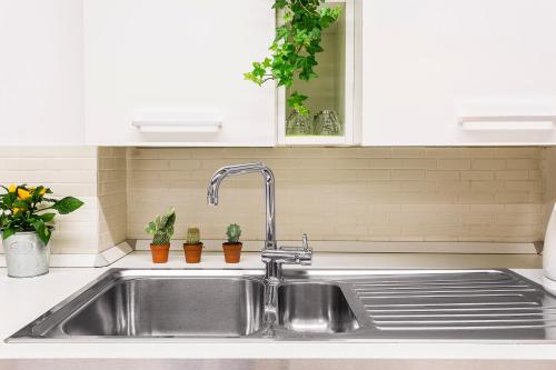 a kitchen sink with a faucet and some plants at Cà Biennale, scoprire la Venezia nascosta! in Venice