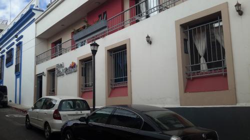 two cars parked on a street next to a building at Hotel Real Colonial in Comitán de Domínguez