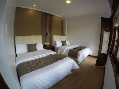 a hotel room with two beds in it at Siena Hotel in Cuenca