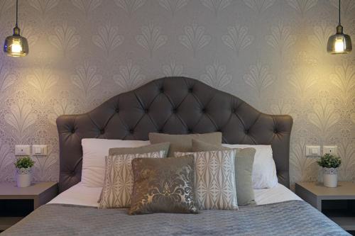 a bedroom with a large bed with a leather headboard at Lainez Rooms & Suites in Trento