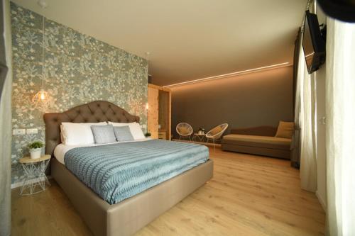 a bedroom with a bed and a couch at Lainez Rooms & Suites in Trento