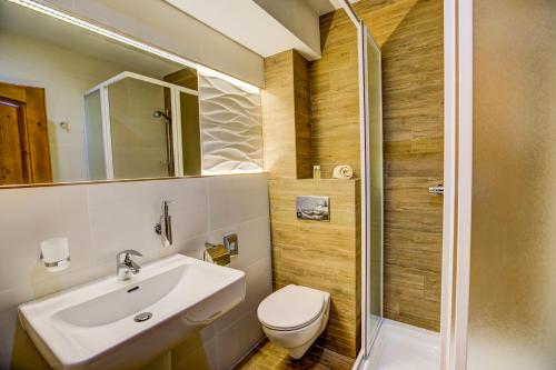 a bathroom with a sink and a toilet and a shower at Hotel Strachanovka - Jánska Koliba in Liptovský Ján