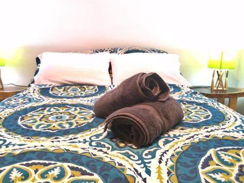 a bed with a rolled up towel on it at Guesthouse Casa Lapa in Alajuela City