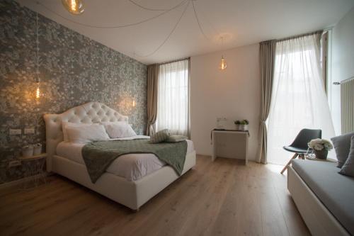 a bedroom with a large bed and a couch at Lainez Rooms & Suites in Trento