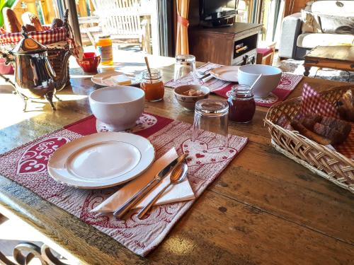 une table en bois avec des assiettes et des ustensiles dessus dans l'établissement Chalet de Barraou, à Binos