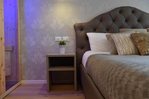 a bedroom with a bed and a table with a night stand at Lainez Rooms & Suites in Trento