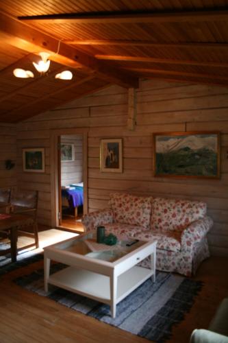 a living room with a couch and a coffee table at Tallhöjden Hotel & Cottage Lodge in Simlångsdalen