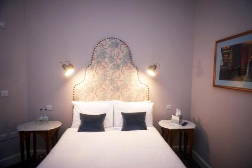 a bedroom with a large bed with a large headboard at Embankment Hotel in Bedford