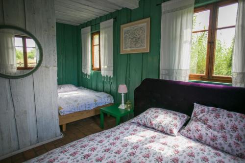 una camera da letto con pareti verdi, un letto e uno specchio di Pan tu nie spal a Gałkowo