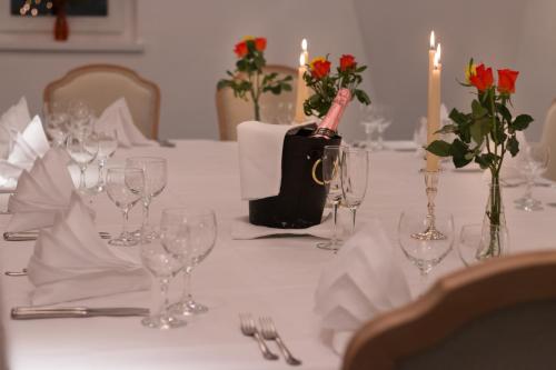 a table with glasses and a bottle of wine on it at Hotel Schloss Romanshorn in Romanshorn