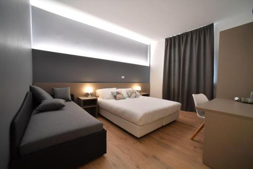 a hotel room with a bed and a couch at Lainez Rooms & Suites in Trento