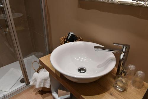 a bathroom with a white sink and a shower at Lainez Rooms & Suites in Trento