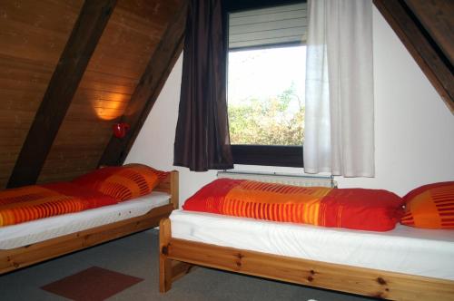 2 Betten in einem Zimmer mit Fenster in der Unterkunft Ankerplatz Twielenfleth in Twielenfleth
