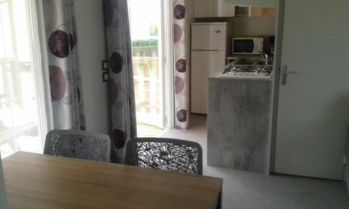 a kitchen with a table and a stove and a refrigerator at CAMPING PARADIS Domaine Oyat in Le Fenouiller