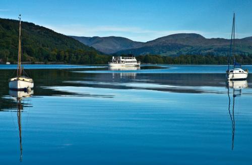 two boats in a large body of water with mountains at Ivythwaite Lodge Guest House in Windermere