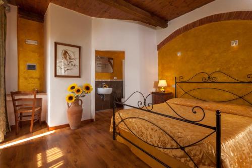 een slaapkamer met een bed en een vaas met bloemen bij Agriturismo Nibbiano in Montepulciano