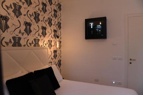 a bedroom with a bed and a wall with a wallpaper at Lainez Rooms & Suites in Trento
